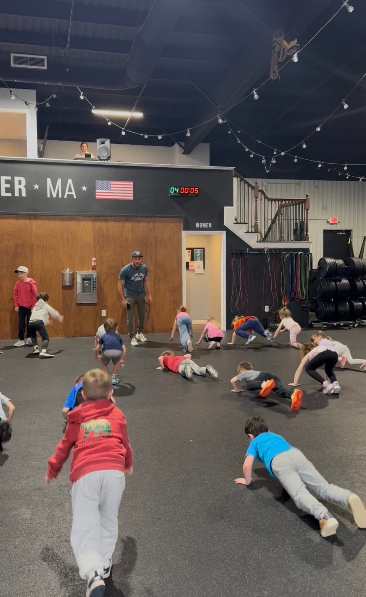 Kids doing a floor exercise drill in a coached line